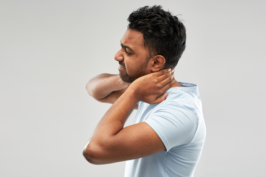 side profile of a man clutching his neck in pain